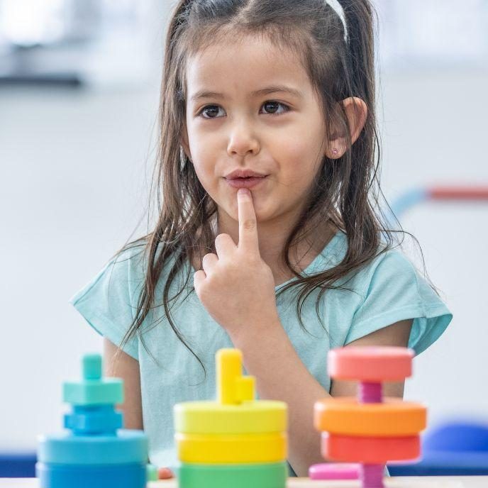 young child pointing at her lips during paediatric occupational therapy session