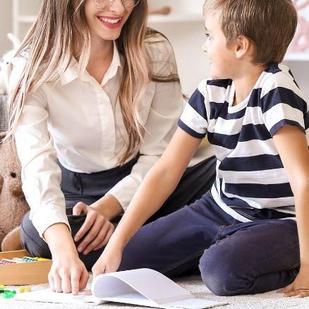 Young boy reading with therapist during kids OT session